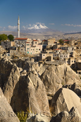 Houses and Mosque in Ortasihar with view of Mount Erciyes and fairy chimneys Cappadocia Turkey
