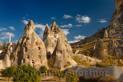 Ancient cave houses carved in volcanic tuff at Uchisar at sunset Cappadocia Turkey