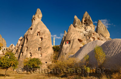 Ancient cave houses carved out of volcanic tuff at Uchisar with evening sun Cappadocia Turkey