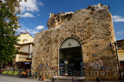 Antalya street with shops and ancient stone building used as a china store in Turkey