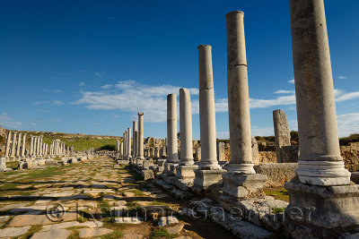 Colonade and canal on the main street of Perge archaeological site Turkey under the Acropolis