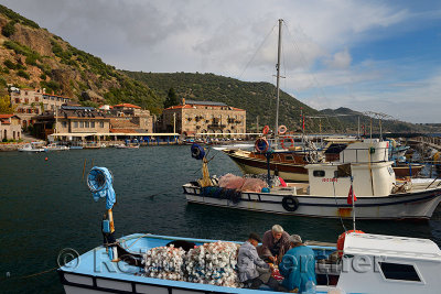 Fishermen having lunch on  boat at harbour of Assos Iskele Behram Turkey