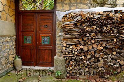 Ornate doorway with wood pile in ancient hillside village of Yesilyurt Malatya Turkey