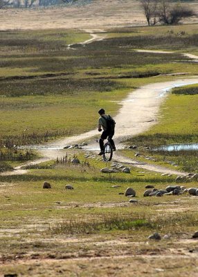 Unicyclist riding a dirt trail