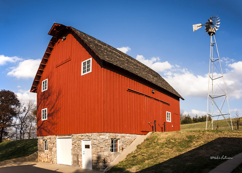 A bright red barn, a bright blue sky, a few clouds and a windmill all on a warm fall day.
An image may be purchased at http://edward-peterson.artistwebsites.com/featured/coddington-barn-edward-peterson.html