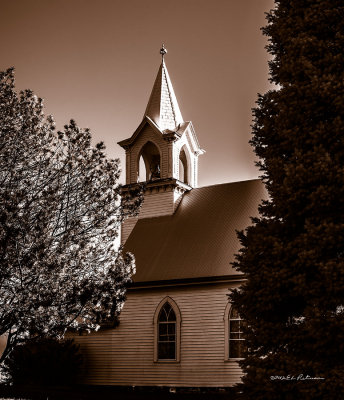 As you stand in the road to see the church through the trees you can almost see the horse and buggies pulling up.
An image may be purchased at http://edward-peterson.artistwebsites.com/featured/st-johns-lutheran-church-in-the-trees-edward-peterson.html
