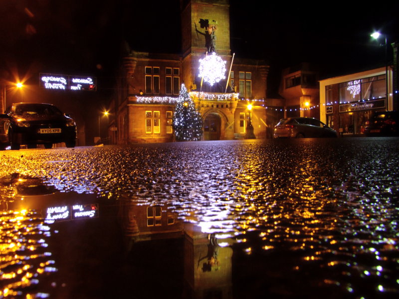 Annan  Old  Town  Hall, reflecting  in  a  puddle.