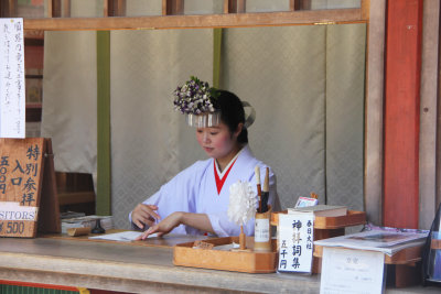 Beautiful Japanese girl working at the entrance to the shrine.