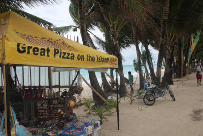 A pizza joint and tourist shop on the beach.