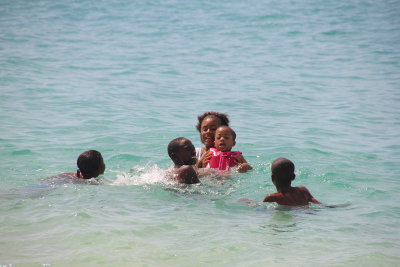 A family enjoying the water at Grand Anse Beach.