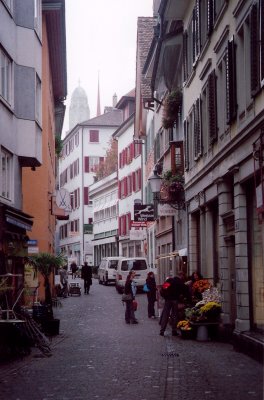 A narrow street with a flower vendor.