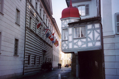 A quaint street in Lucerne with typical Swiss architecture and flags.