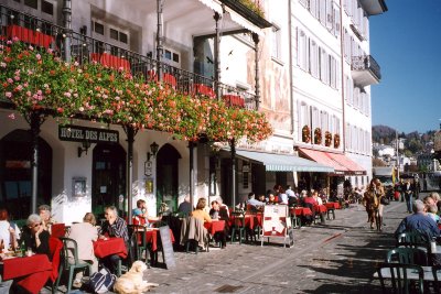 People having lunch at an outdoor cafe along the edge of  the Reuss River.