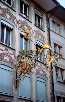 Wrought iron decoration with gold leaf on the side of a building in the old city.