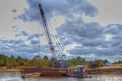 Scooping material from the barge to the shore - Image 1