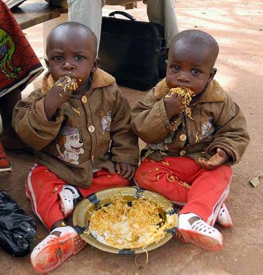 Little twins sharing their lunch in Burkina Faso
