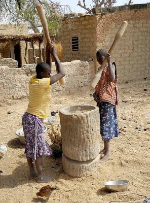 Girls threshing millet by pounding the grains, Burkina Faso