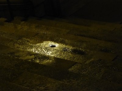 Light reflecting on small puddle on stairs