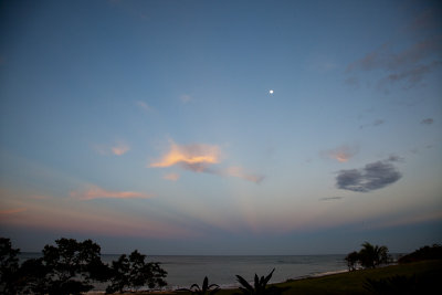 Anti-crepuscular rays and the moon at sunrise over the Pacific.