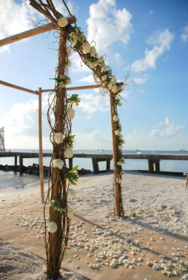 Bamboo arch with trigs and white florals. By: Kate Bahnsen