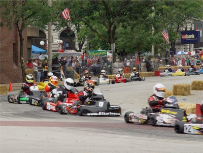 KYLE DRIVES THE GREY #33 KART MID-PACK UNDER THE AMERICAN FLAG ON THE RIGHT AT THE BEGINNING OF THE RACE
