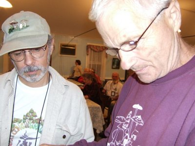 Joe Brandt & George Johanson look over mushroom books awaiting auctioning. 4638.JPG