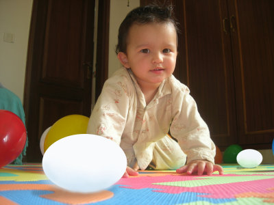 Infant Rahil with toy eggs.