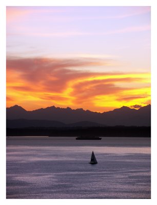 Sailboat Enjoys a Sunset Over Elliot Bay and the Olympic Mountains