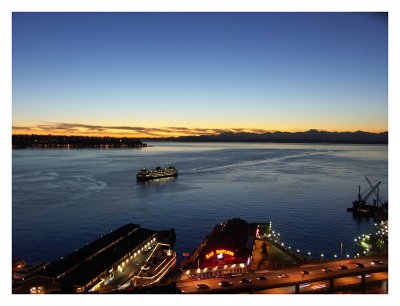 Ferry Approaches Waterfront Against a Background of a Sunset Over Elliot Bay and the Olympic Mountains
