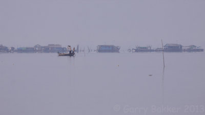 Fishermen with floating village in the background