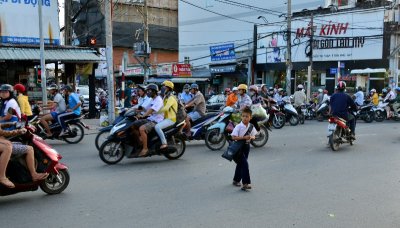 brave kid, rush hour, crazy scooter traffics, Saigon, Vietnam 