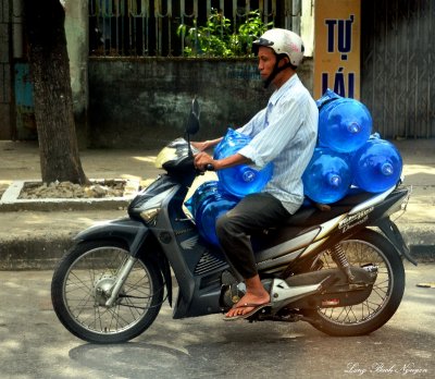 water delivery on scooter, Vietnam 