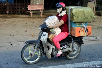 fully loaded masked scooter driver, My Tho, Vietnam  