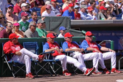 The coaches sit outside the dugouts in Spring Training
