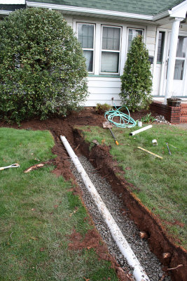 You dig trenches, lay pipe out to the street and connect the downspouts to the pipes.