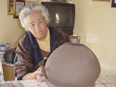 Consolacion uses a broken Hacksaw blade to smooth the sides of the olla (pot)