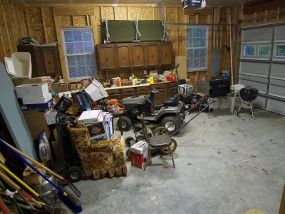 Spacious 2 car garage with riding mower and old kitchen cabinates