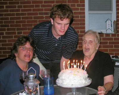 Sandy and Chris helping Mom blow out candles