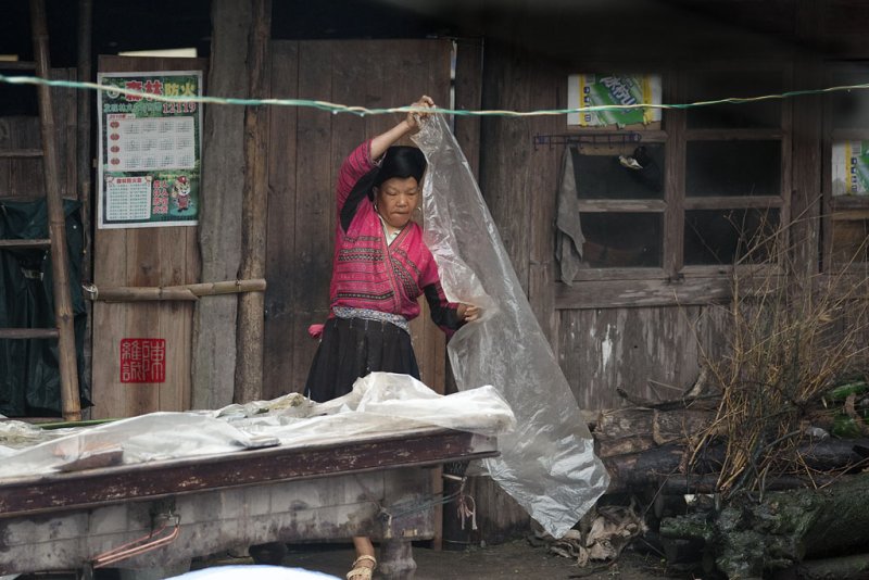 Putting on a rain cover, DaXai village, Long Ji, China