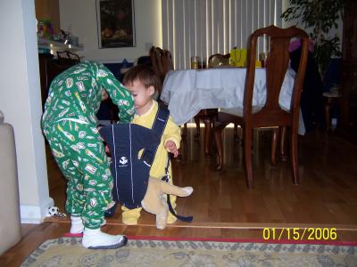 Ben helping Evan make sure his toy puppy is safe and secure in the baby carrier