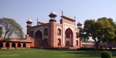 The Taj Mahal complex is bounded by a crenellated red sandstone wall on three sides.