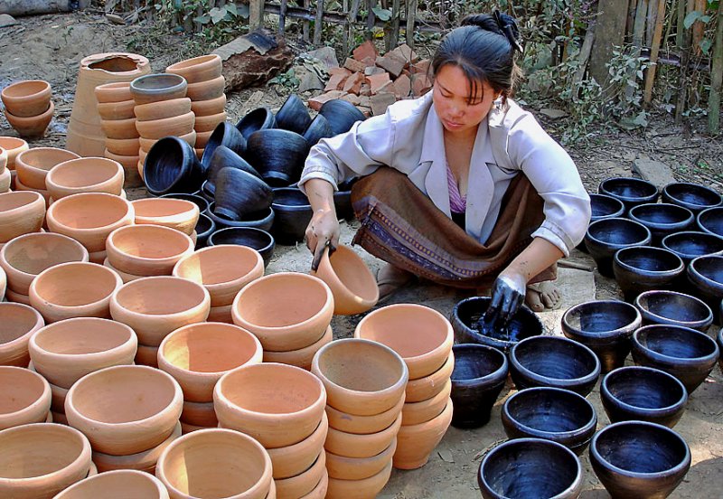 Woman staining pots, close up