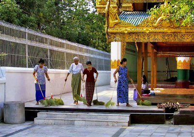 Women sweeping temple courtyard