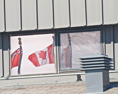 Flags reflected in window of Government Building