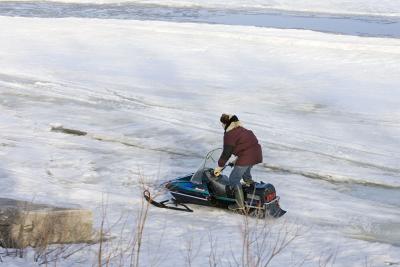 Snowmobile on ice along shore