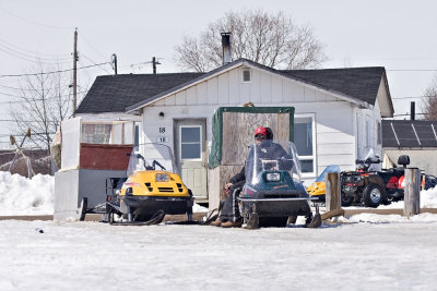 Snowmobile taxis waiting for passengers at the top of McCauley's Hill in Moosonee
