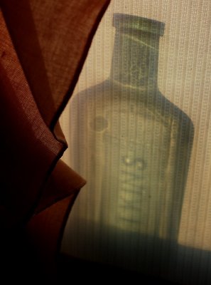 Glass Bottle Behind Window Shade