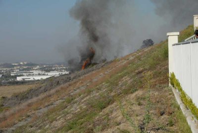 Fire comes around the bend behind the house