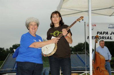 Betty presents banjo to raffle winner Andrea Deyrup of Greenville