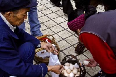 Chicken eggs being sold on sidewalk market.
